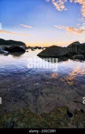 Eaux calmes entre les rochers de grès de la plage de Hams de la côte Pacifique dans la ville de plage Australia Caves. Banque D'Images