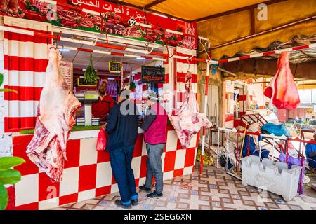 AGDZ TOWN, MAROC - 13 nov 2023 : hommes achetant de la viande à la boucherie traditionnelle dans la ville d'Agdz dans les montagnes de l'Atlas, Maroc, Afrique du Nord. Banque D'Images