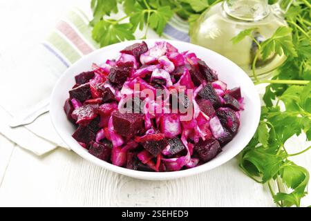 Salade Vinaigrette au vinaigre ou avec de la choucroute, pommes de terre, betterave et oignons, assaisonné d'huile végétale dans un bol, serviette, le persil sur l'arrière-plan Banque D'Images