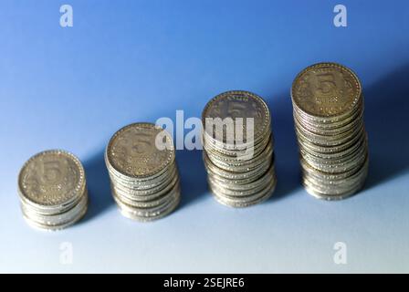 Concept, croissance indienne cinq pièces de monnaie de roupies arranger en pile sur fond blanc bleu Banque D'Images