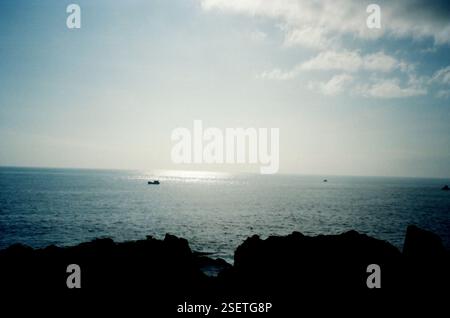 Vaste océan avec des bateaux sous un ciel radieux, capturé sur film 35mm. Fuji C200 - 24 Banque D'Images