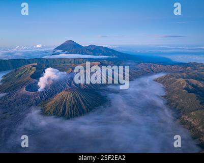 Vue aérienne du Mont bromo à couper le souffle entouré de brume et de paysages spectaculaires. Volcan actif en Indonésie, la douce lumière du matin se met en évidence Banque D'Images