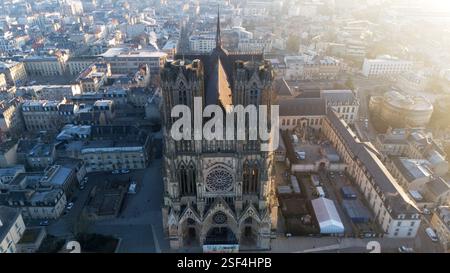 Superbe vue aérienne de la cathédrale de Reims en France, mettant en valeur son architecture gothique et le paysage urbain environnant au lever du soleil. Banque D'Images