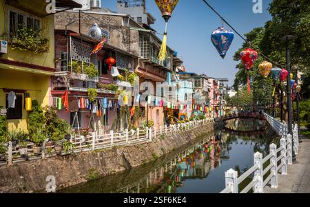 Lanternes colorées et maisons peintes décorées le long de la voie navigable du lac truc bac séparant l'île de Ngu Xa du continent, Hanoi, Vietnam. Banque D'Images