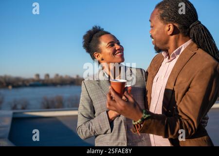 Un homme et une femme d'affaires joyeux habillé dans chic décontracté ayant une conversation sur le café en pause Banque D'Images
