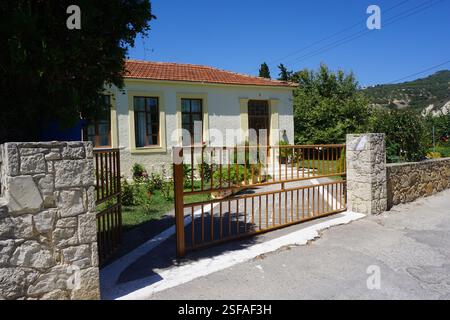 Un bâtiment traditionnel à la Canée avec un toit en tuiles et un beau jardin plein de fleurs et de plantes, un jeu traditionnel, « koutso » et une aire de jeux Banque D'Images
