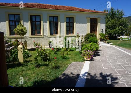 Un bâtiment traditionnel à la Canée avec un toit en tuiles et un beau jardin plein de fleurs et de plantes, un jeu traditionnel, « koutso » et une aire de jeux Banque D'Images