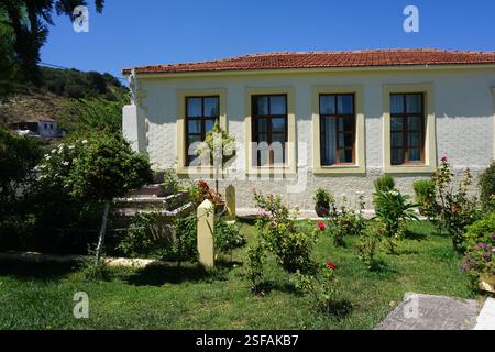 Un bâtiment traditionnel à la Canée avec un toit en tuiles et un beau jardin plein de fleurs et de plantes, un jeu traditionnel, « koutso » et une aire de jeux Banque D'Images