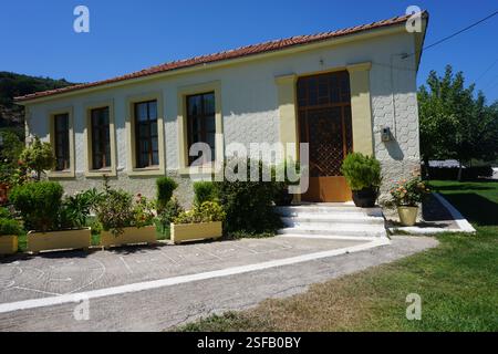 Un bâtiment traditionnel à la Canée avec un toit en tuiles et un beau jardin plein de fleurs et de plantes, un jeu traditionnel, « koutso » et une aire de jeux Banque D'Images