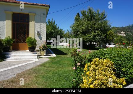 Un bâtiment traditionnel à la Canée avec un toit en tuiles et un beau jardin plein de fleurs et de plantes, un jeu traditionnel, « koutso » et une aire de jeux Banque D'Images