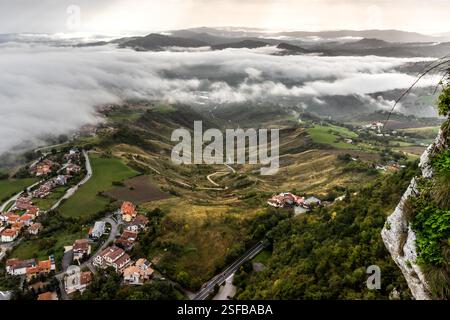 Vue de Monte Titano (Saint-Marin) à un complexe industriel au bout de la vallée. Là, derrière les nuages, de l’autre côté, se trouve la murale « L’histoire de Saint-Marin » de l’artiste brésilien Eduardo Kobra Banque D'Images