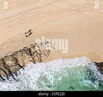 Vue aérienne d'un pêcheur pêchant et deux personnes debout sur la plage de Sotovento, Costa Calma, Fuerteventura, îles Canaries, Espagne Banque D'Images