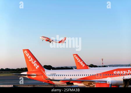 Aéroport de Bristol Royaume-Uni. Un avion easyjet décolle tôt le matin. Les avions easyJet sont montrés stationnés sur la piste Banque D'Images