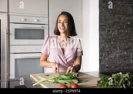 Femme prépare des légumes frais sur une planche à découper Banque D'Images