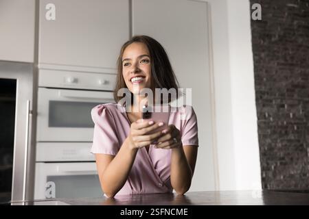 Jolie jeune femme utilisant son smartphone à la maison Banque D'Images