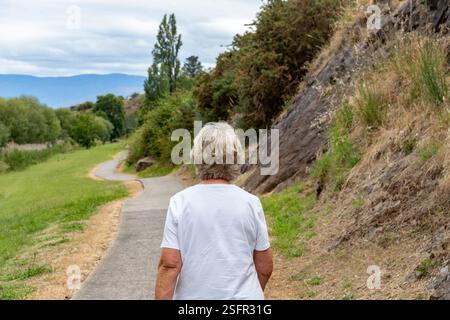 Femme âgée marchant sur un sentier naturel à travers jordan River Trail Park Land Tasmanie Banque D'Images