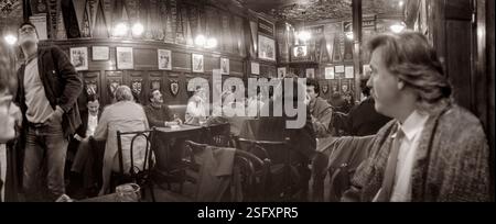 Un photographe américain expatrié Murray Lemley (à droite) avec des clients et des touristes au Harry’s New York Bar, Paris, France 1987. Banque D'Images