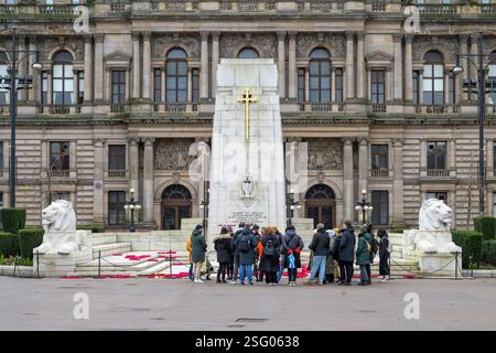 Un groupe de visite et un guide sur George Square à côté du cénotaphe et de City Chambers, Glasgow, Écosse, Royaume-Uni, Europe Banque D'Images