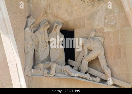 Sculpture en pierre représentant une scène de deuil et de travail, avec des personnages en robes et un homme travaillant avec une poutre en bois. L'œuvre d'art transmet des thèmes Banque D'Images