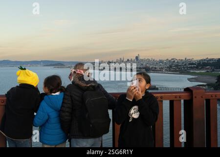 Enfants sur le Golden Gate Bridge à San Francisco, CA, prenant des photos de la ville. Banque D'Images