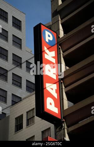 Panneau de stationnement (PARK P) sur un garage à plusieurs étages, probablement à San Francisco, CA, attaché à un bâtiment en briques de couleur claire. Banque D'Images