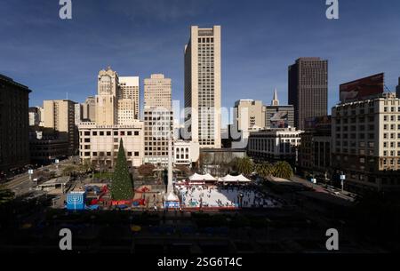 Patinoire à Union Square, San Francisco, avec un sapin de Noël et une grande menorah. Les gens patinent et apprécient l'atmosphère de vacances. Banque D'Images
