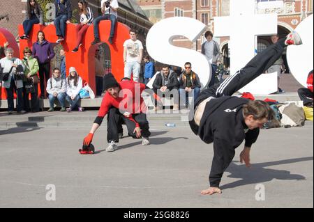 La culture vibrante d'Amsterdam est pleinement exposée tandis qu'ils divertissent une foule qui se rassemble. Les artistes énergiques mettent en valeur leurs mouvements impressionnants, figeant Banque D'Images