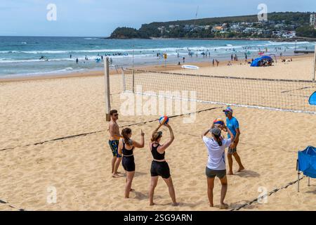 Cours de volley-ball de plage, sur Manly Beach à Sydney entraîneur de volley-ball donne des leçons sur le maniement du ballon à un groupe de joueurs débutants, NSW, Australie Banque D'Images