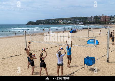 Cours de volley-ball de plage, sur Manly Beach à Sydney entraîneur de volley-ball donne des leçons sur le maniement du ballon à un groupe de joueurs débutants, NSW, Australie Banque D'Images