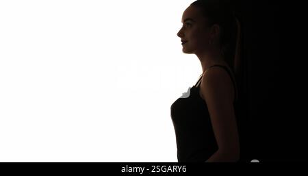 Silhouette de beauté. Cosmétologie esthétique. Contour de profil de contraste sombre du visage souriant de femme confiante isolé sur fond d'espace vide blanc. Banque D'Images