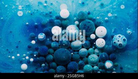 Bulle d'huile. Mélange de peinture. Gouttes de gel coloré flottant sur la surface de l'eau de marbre. Fond liquide de particules abstraites blanches bleues fantastiques. Banque D'Images