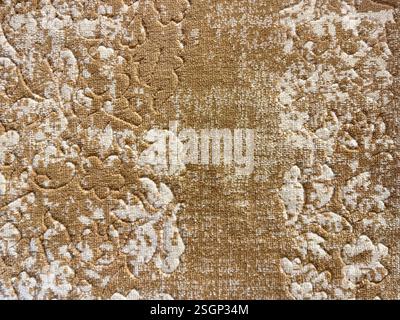 Texture de tapis abstrait aléatoire dans un motif ornemental floral avec une couleur brun doré. Banque D'Images