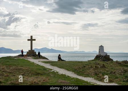 Phare de TWR Mawr et vieille croix de pierre à la pointe de Ynys Llanddwyn, une petite île sur Anglesey, au nord du pays de Galles. Banque D'Images