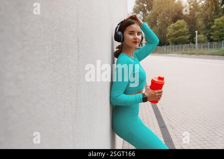 Belle femme athlète de fitness buvant de l'eau après l'exercice de travail. Femme buvant de l'eau de la bouteille. Eau potable féminine après des exercices ou Banque D'Images