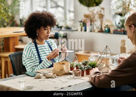 Les amis s'engagent dans un atelier amusant, fabriquant des arrangements succulents uniques ensemble. Banque D'Images