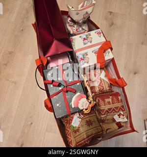 Un panier vibrant et coloré débordant de cadeaux magnifiquement emballés destinés à la joyeuse saison des fêtes Banque D'Images