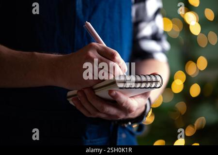 Serveur écrivant une commande dans Un bloc-notes pendant Noël Banque D'Images