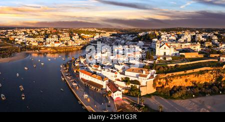 Ferragudo, Portugal : le plus joli village traditionnel de pêche de la côte de l'Algarve, près de la ville de Portimao. vue panoramique aérienne panoramique sur le coucher du soleil Banque D'Images