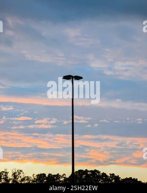 Silhouette de la lumière de rue contre le lever/coucher de soleil vibrant ciel Banque D'Images