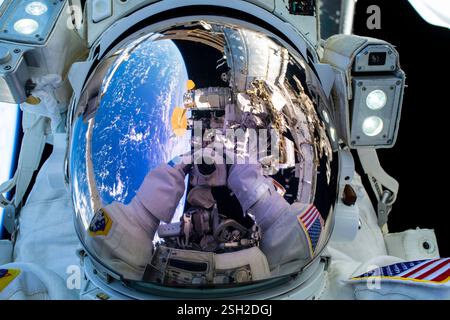 ISS - 30 janvier 2025 - la caméra de l'astronaute de la NASA et commandant de l'expédition 72 Suni Williams se reflète dans la visière de son casque spatial lorsqu'elle la pointe Banque D'Images