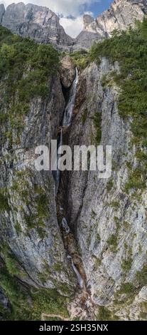 Prise de vue verticale de Cascate del Pisciadù dans les Dolomites, en Italie, avec des cascades en cascade, des falaises de calcaire escarpées et une végétation alpine luxuriante Banque D'Images