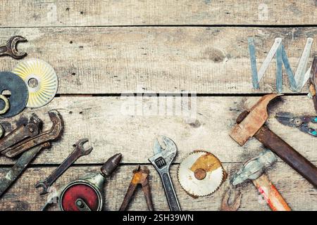 Divers outils à main disposés sur un établi rustique en bois dans un cadre d'atelier montrant l'artisanat et les activités d'entretien Banque D'Images