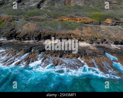 Côte accidentée avec des roches volcaniques et des vagues turquoises à Oahu Banque D'Images