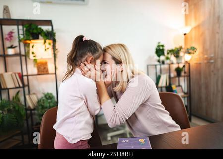 Mère partage un moment tendre avec sa fille dans un cadre intérieur cosy Banque D'Images