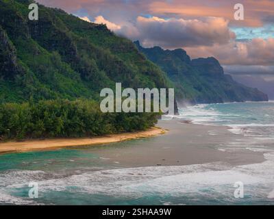 Vue aérienne des falaises de la côte de Napali et des eaux turquoise au coucher du soleil Banque D'Images