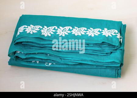 Un beau saree en coton bleu-vert fait à la main est affiché sur un fond en bois clair. Beaucoup de femmes bengali portent des sarees tous les jours, ainsi que sur l'occa spéciale Banque D'Images