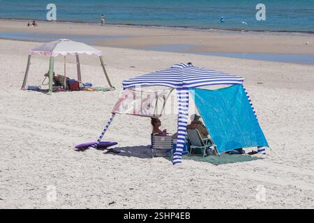 Adélaïde, Australie, 11 février 2025. Les amateurs de plage s'abritant sous un gazebo de plage du soleil chaud dans la banlieue de Grange. Un avertissement de vague de chaleur « code rouge » a été émis pour les parties de l'Afrique du Sud dont les températures devraient atteindre 40 °c. Crédit. Amer Ghazzal/Alamy Live News Banque D'Images
