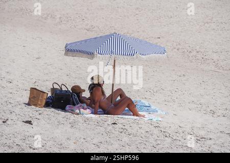 Adélaïde, Australie, 11 février 2025. Les amateurs de plage s'abritant sous un grand parasol du soleil chaud dans la banlieue de Grange. Un avertissement de vague de chaleur « code rouge » a été émis pour les parties de l'Afrique du Sud dont les températures devraient atteindre 40 °c. Crédit. Amer Ghazzal/Alamy Live News Banque D'Images