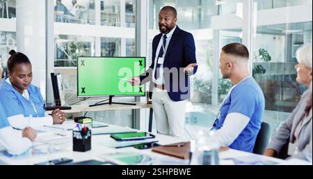 Médecin, coach et présentation avec écran vert pour la formation, la réunion ou la discussion en cabinet de soins de santé. Mentor, leader ou conférencier avec l'équipe médicale Banque D'Images