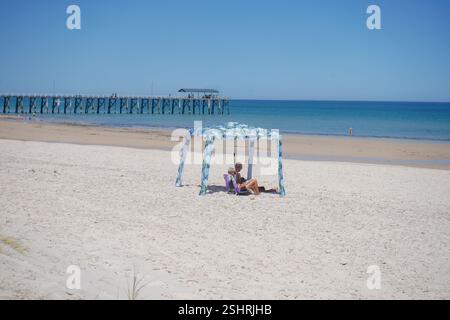 Adélaïde, Australie, 11 février 2025. Les amateurs de plage s'abritant sous le gazebo de la plage du soleil chaud dans la banlieue de Henley. Un avertissement de vague de chaleur « code rouge » a été émis pour les parties de l'Afrique du Sud dont les températures devraient atteindre 40 °c. Crédit. Amer Ghazzal/Alamy Live News Banque D'Images